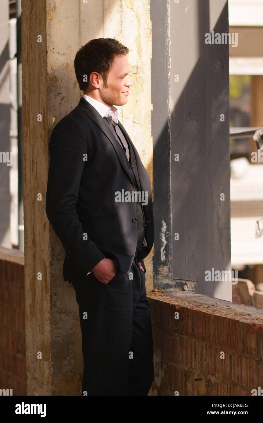 Junger Mann im dunklen Anzug auf einer Baustelle. Stock Photo