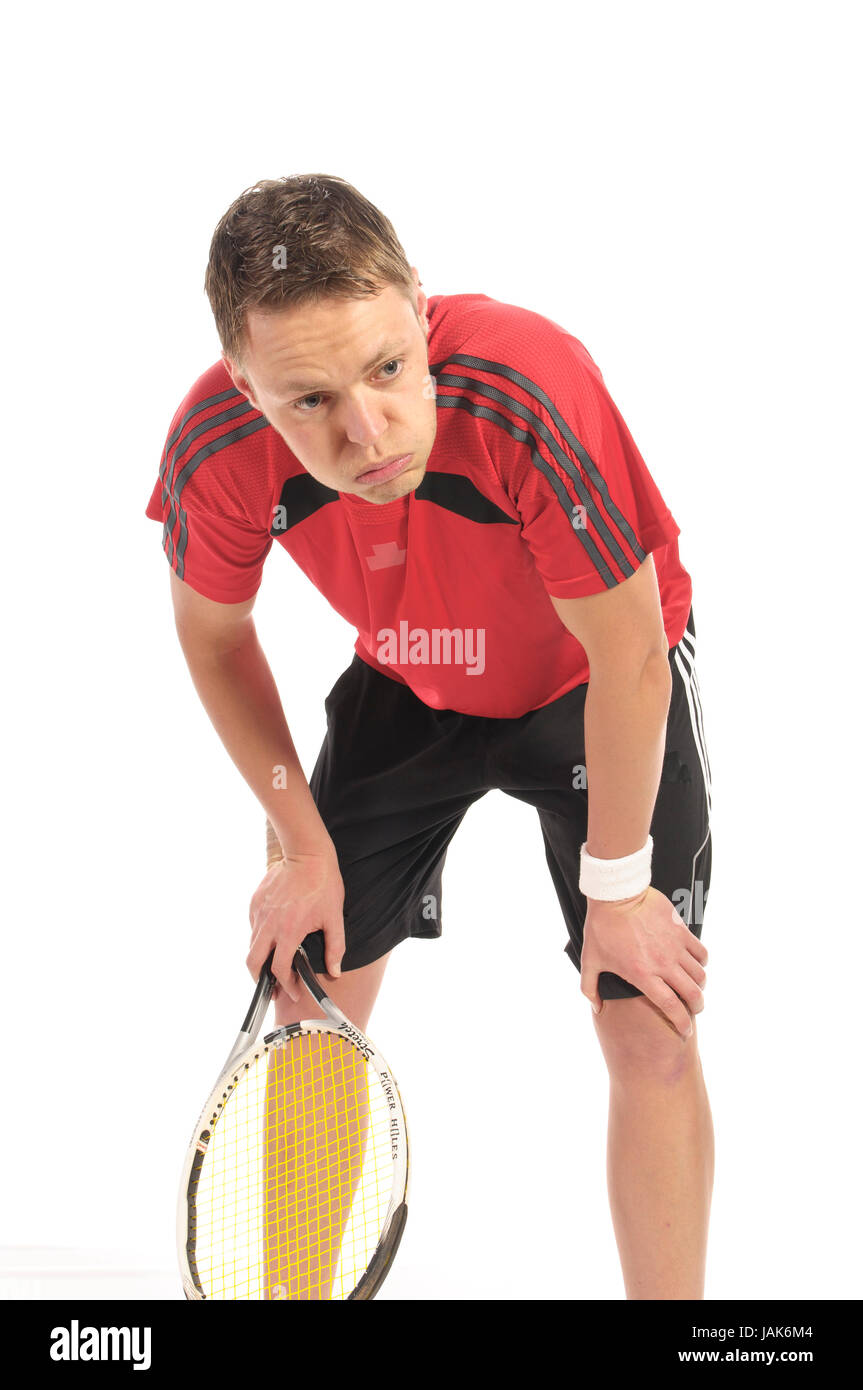 Junger Mann in rotem Tennishirt und Tennisschläger spielt Tennis, isoliert vor weißem Hintergrund. Stock Photo