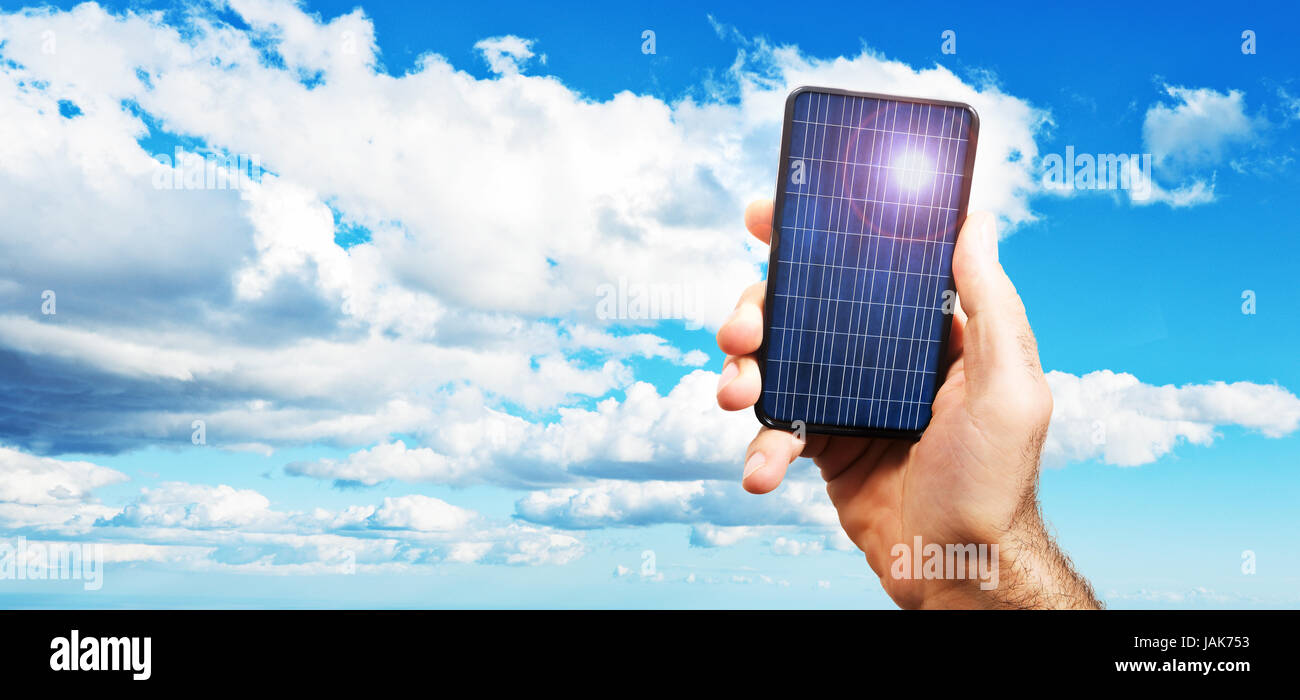 hand of a man holding a photovoltaic cell exposed to the sun. on a background of a blue sky with white clouds of varied Stock Photo