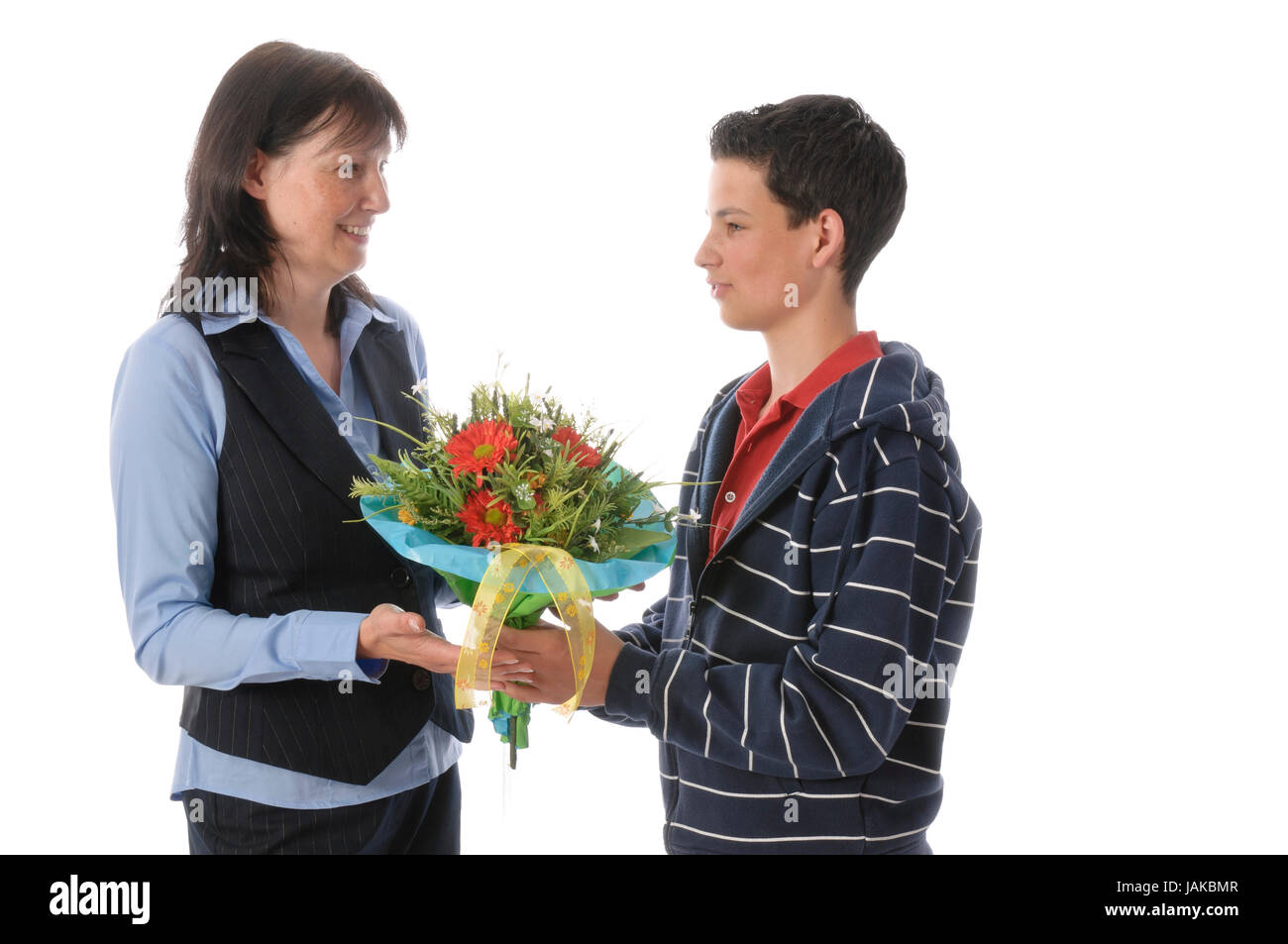 Mutter und ihr jugendlicher Sohn, er überreicht ihr einen Blumenstrauß vor weißem Hintergrund Stock Photo