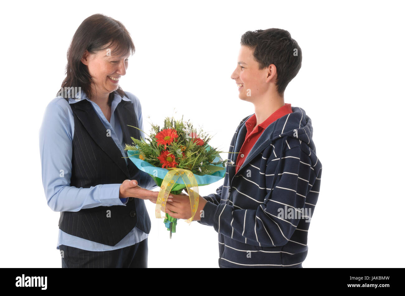 Mutter und ihr jugendlicher Sohn, er überreicht ihr einen Blumenstrauß vor weißem Hintergrund Stock Photo