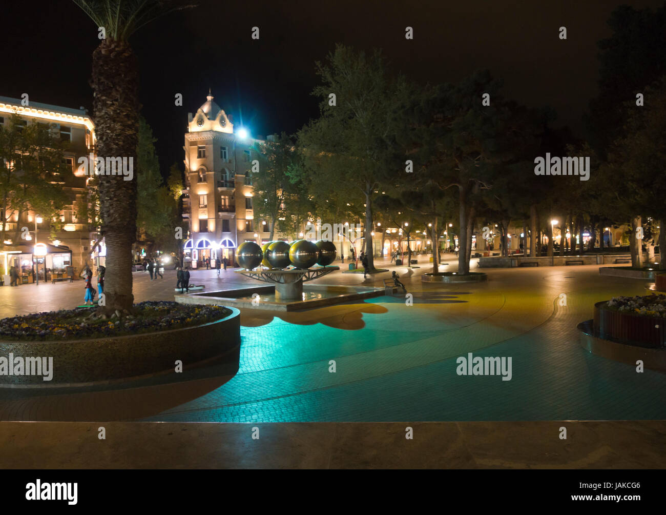 Night-time sightseeing in the inner city of Baku Azerbaijan, beautifully lit buildings and parks, people walking in pedestrian area Stock Photo