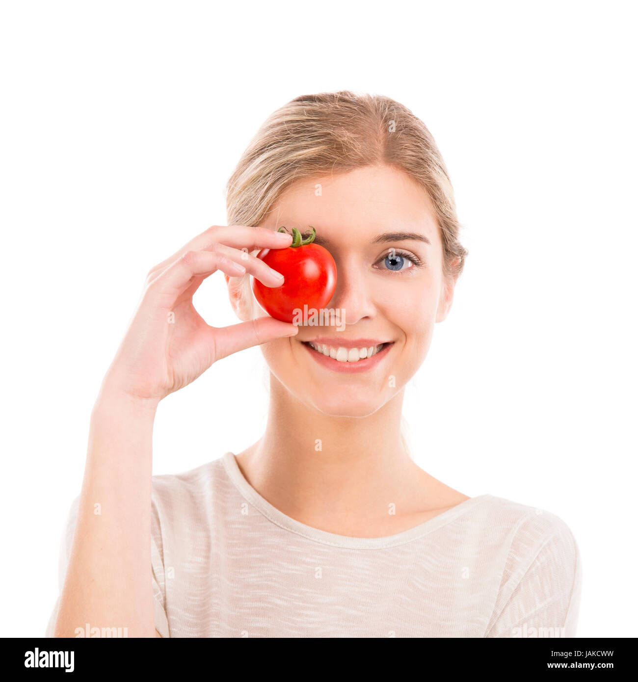 Beautiful girl smiling and holding a red tomato in front of the right ...