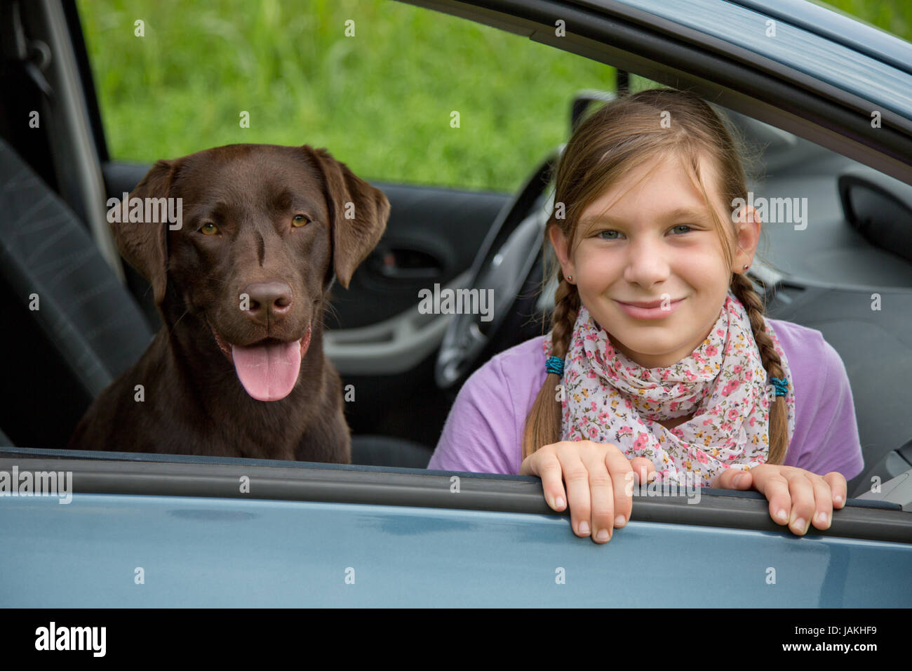 Ein Kind und ein Hund sitzen in einem Auto Stock Photo