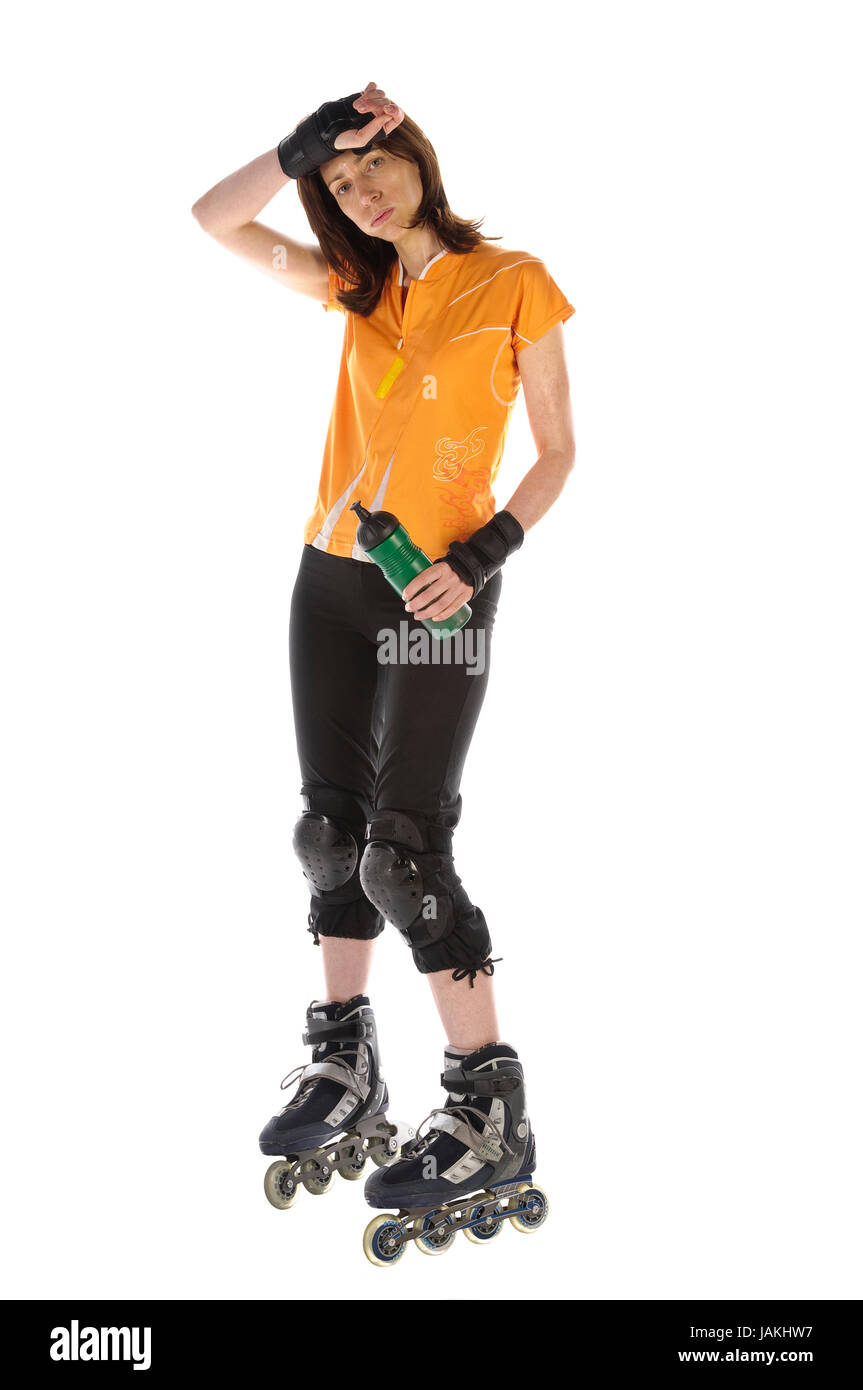 Erwachsene Frau macht Sport auf Inline-Skates und trinkt aus ihrer Wasserflasche vor weißem Hintergrund Stock Photo