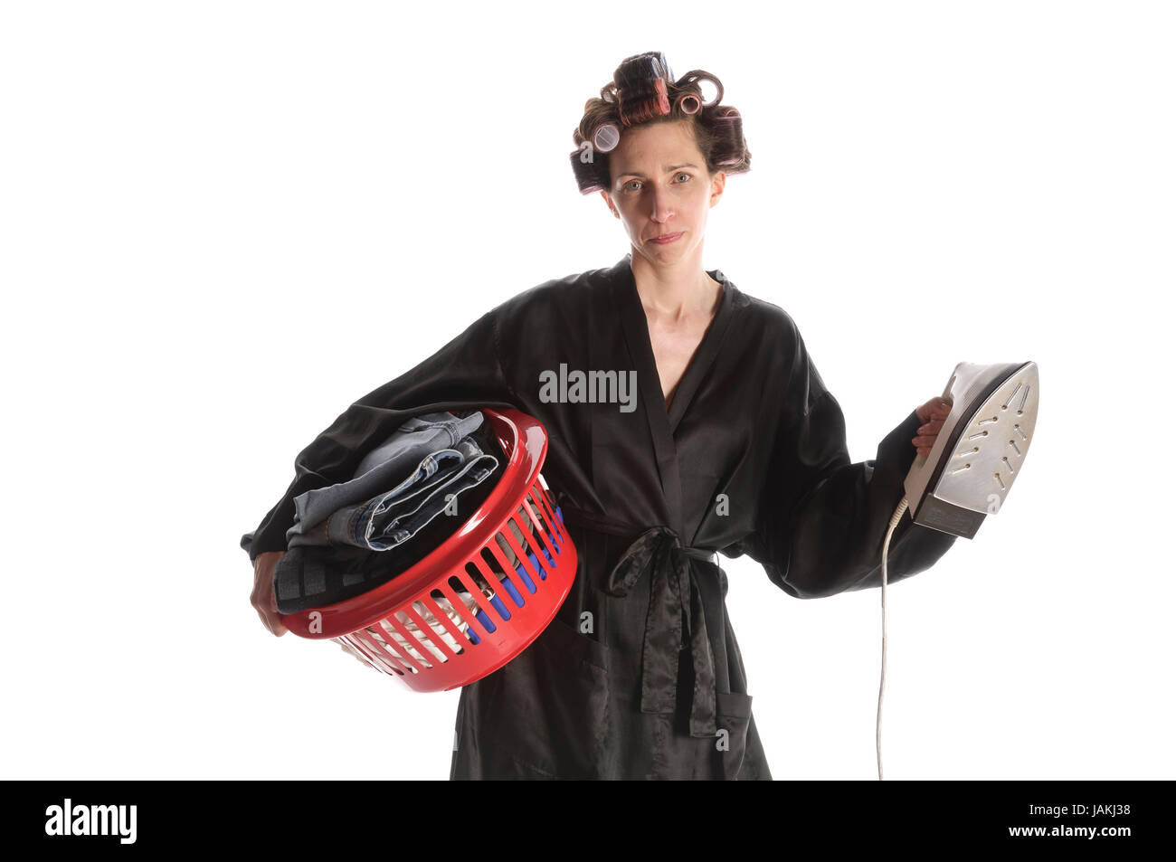 Erwachsene Hausfrau mit Lockenwicklern in den Haaren und einem Bademantel  steht vor weißem Hintergrund und mit einem Korb Bügelwäsche und einem  Bügeleisen Stock Photo - Alamy