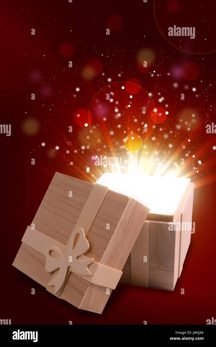 opened gift box that emits a warm and bright light, isolated on a gradient background. Stock Photo