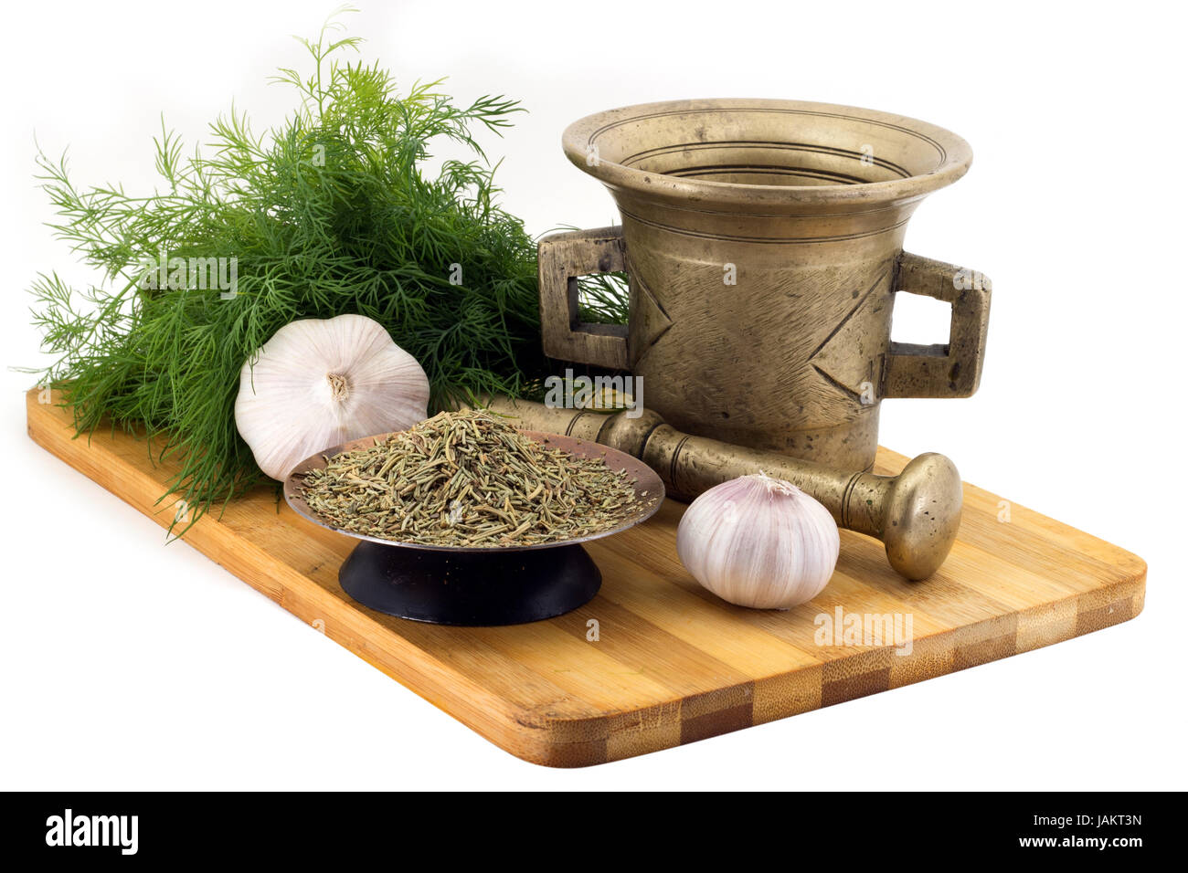 Still Life Spices,rosemary ,marigold staminas in a copper vase on a wooden board on a background of a stern stupa for grinding spices, bunches of dill Stock Photo