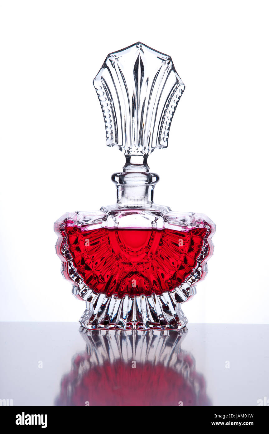 Edler Parfüm-Flakon mit roter Flüssigkeit und Spiegelung vor weißem Hintergrund Stock Photo