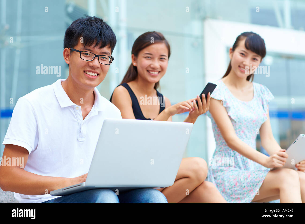 young asian college student using laptop or tablet together outdoor Stock Photo