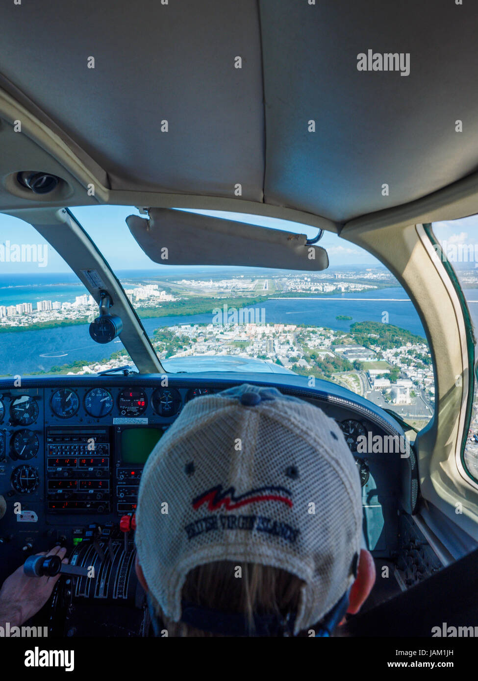 boy copilot in small plane flying over Caribbean islands with pilot Stock Photo