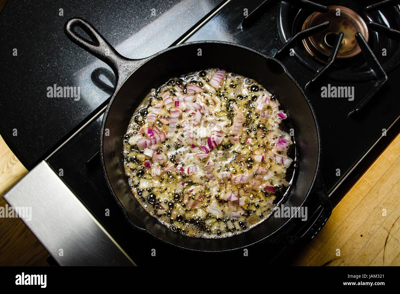 Carmelizing cut red onions in a cast iron skillet Stock Photo Alamy