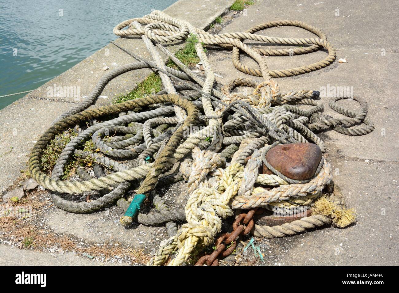 Old mooring rope and chain on a rusty bollard Saundersfoot harbour