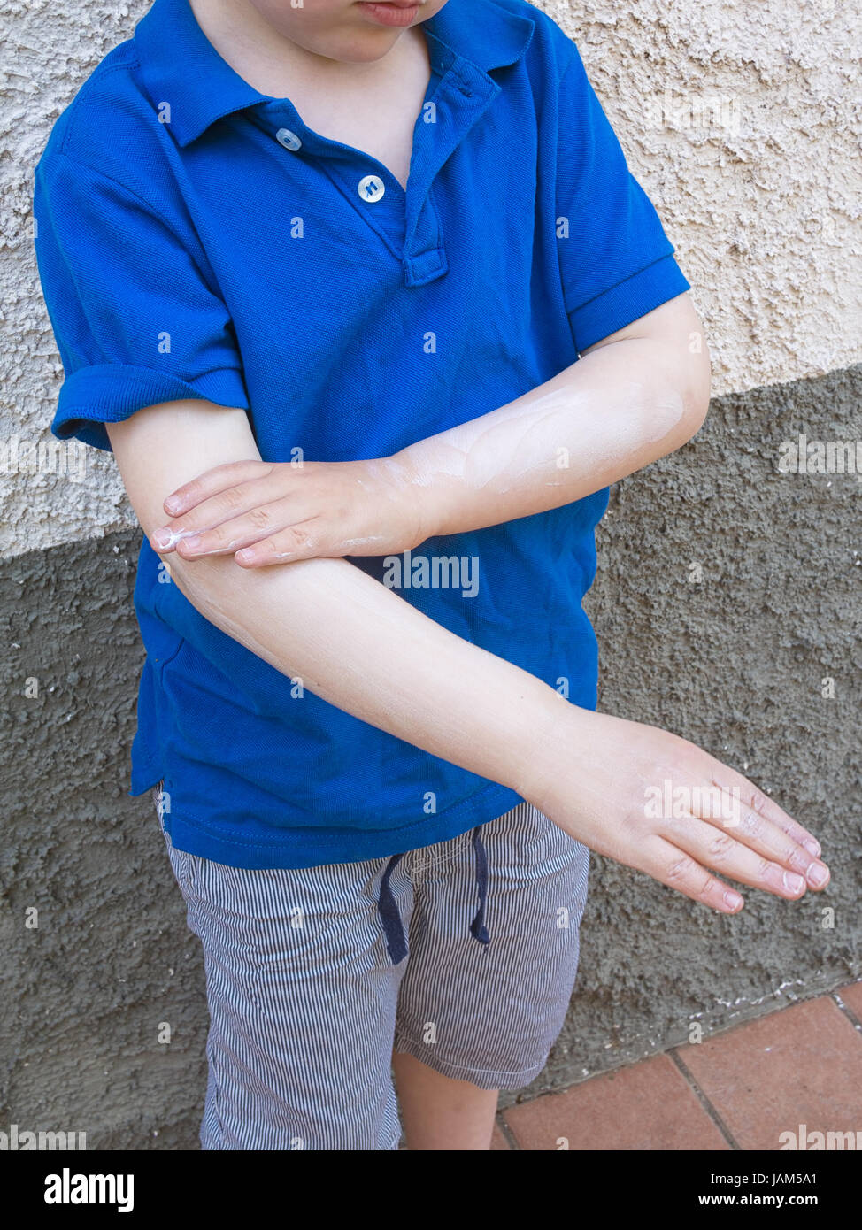 Small boy applying sun protection. Summer holiday. Stock Photo