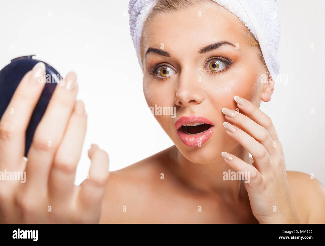 Beautiful young woman looking in the mirror on white background Stock Photo