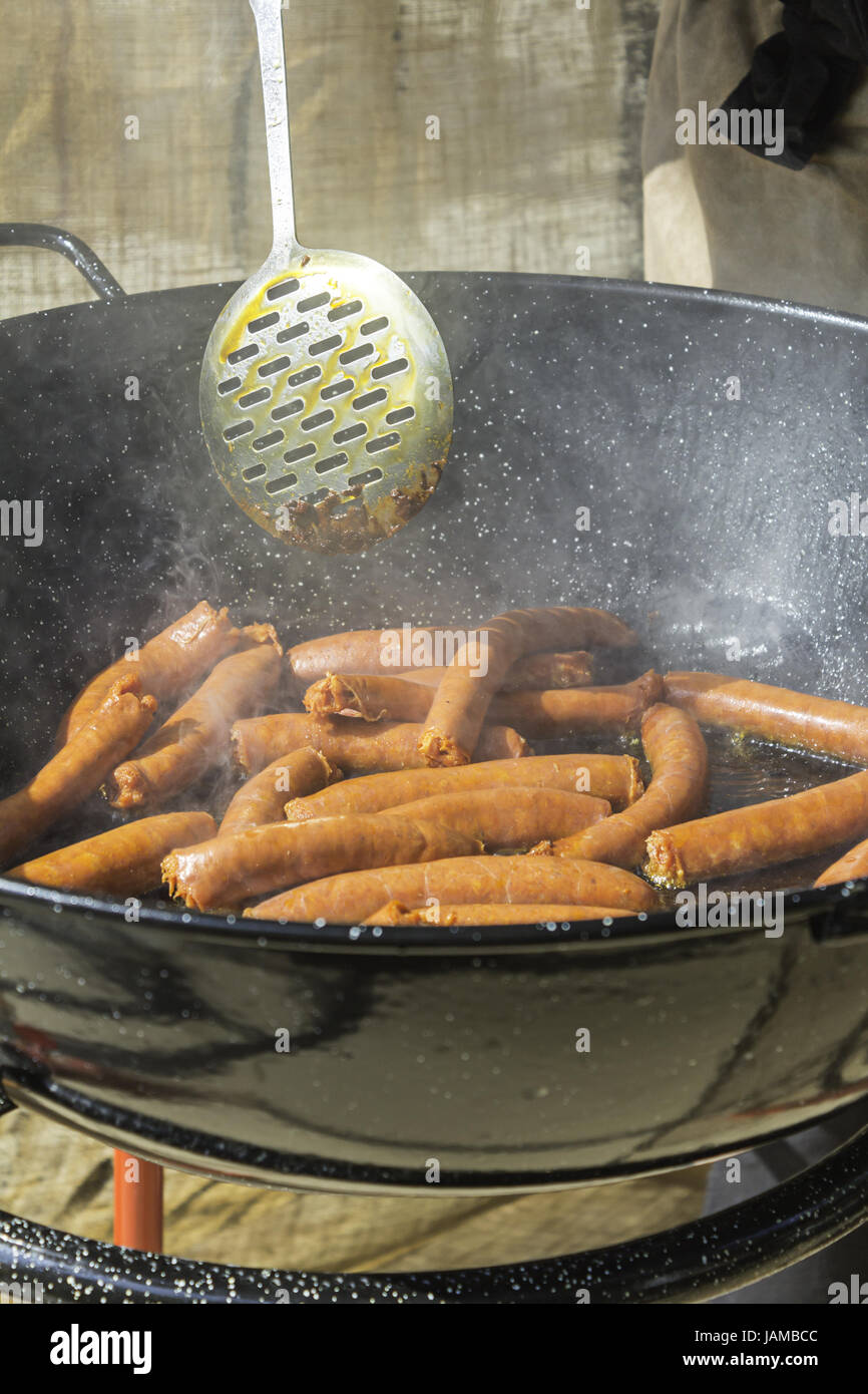 Cooking sausage in skillet with oil in celebration, food Stock Photo