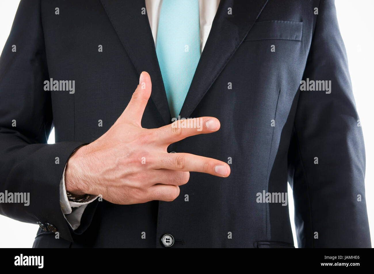 Brust-und-Bauch-Ansicht eines jungen Mannes im schwarzen Anzug mit vor sich gehaltener rechter Hand die '3' anzeigend (drei Finger) Stock Photo