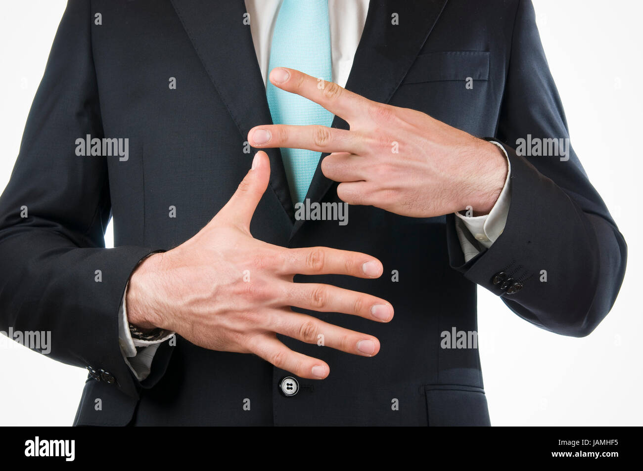 Brust-und-Bauch-Ansicht eines jungen Mannes im schwarzen Anzug mit vor sich gehaltenen Händen die '7' anzeigend (sieben Finger) Stock Photo