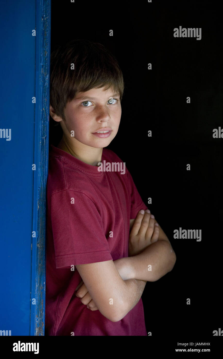 Boy,half portrait,brown-haired,smile,lean,T-shirt,stand red,wall,blue,all alone,youth,teenager,seriously,thoughtfully,young person, Stock Photo