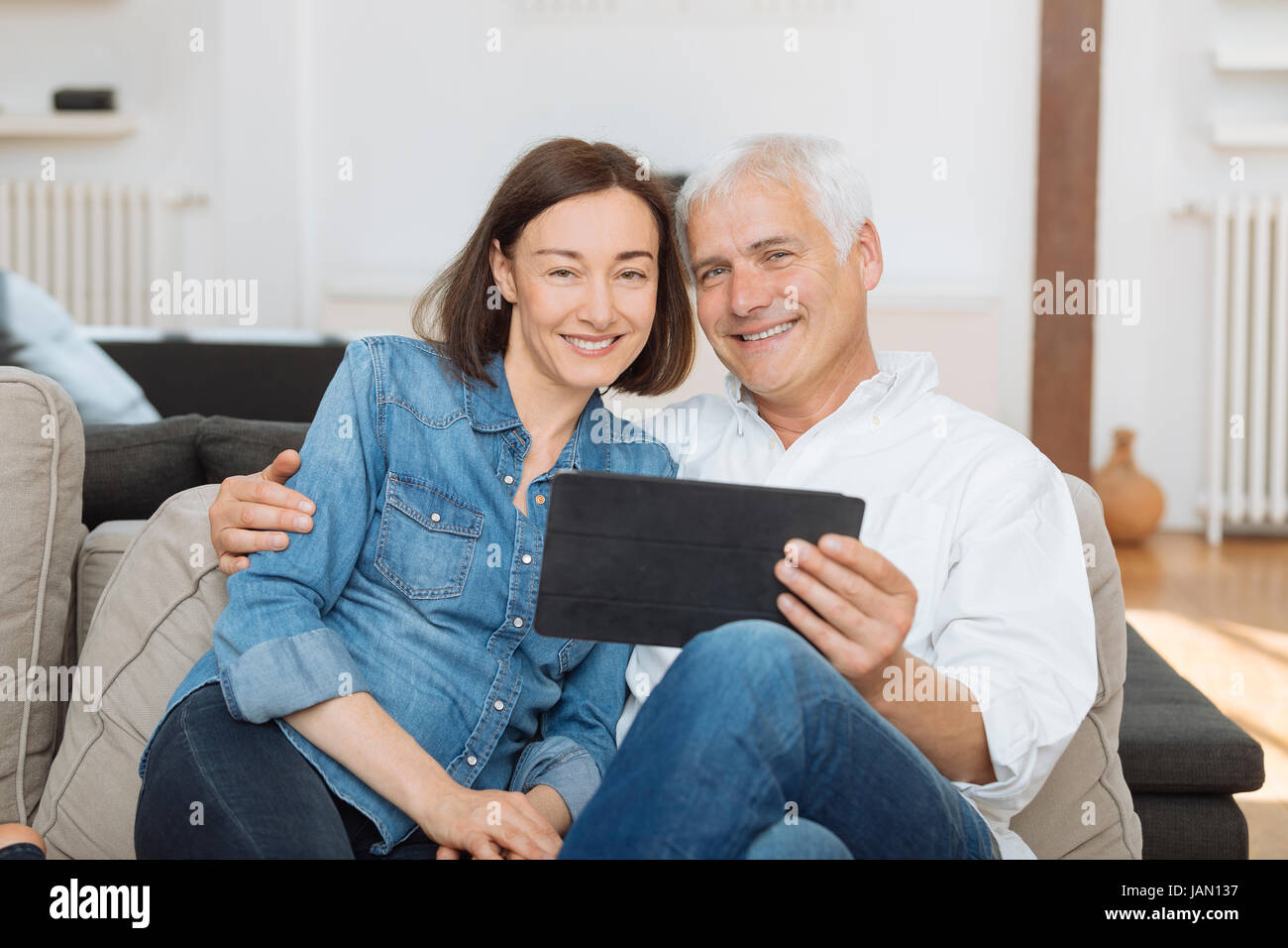 Mature couple at home websurfing with tablet Stock Photo