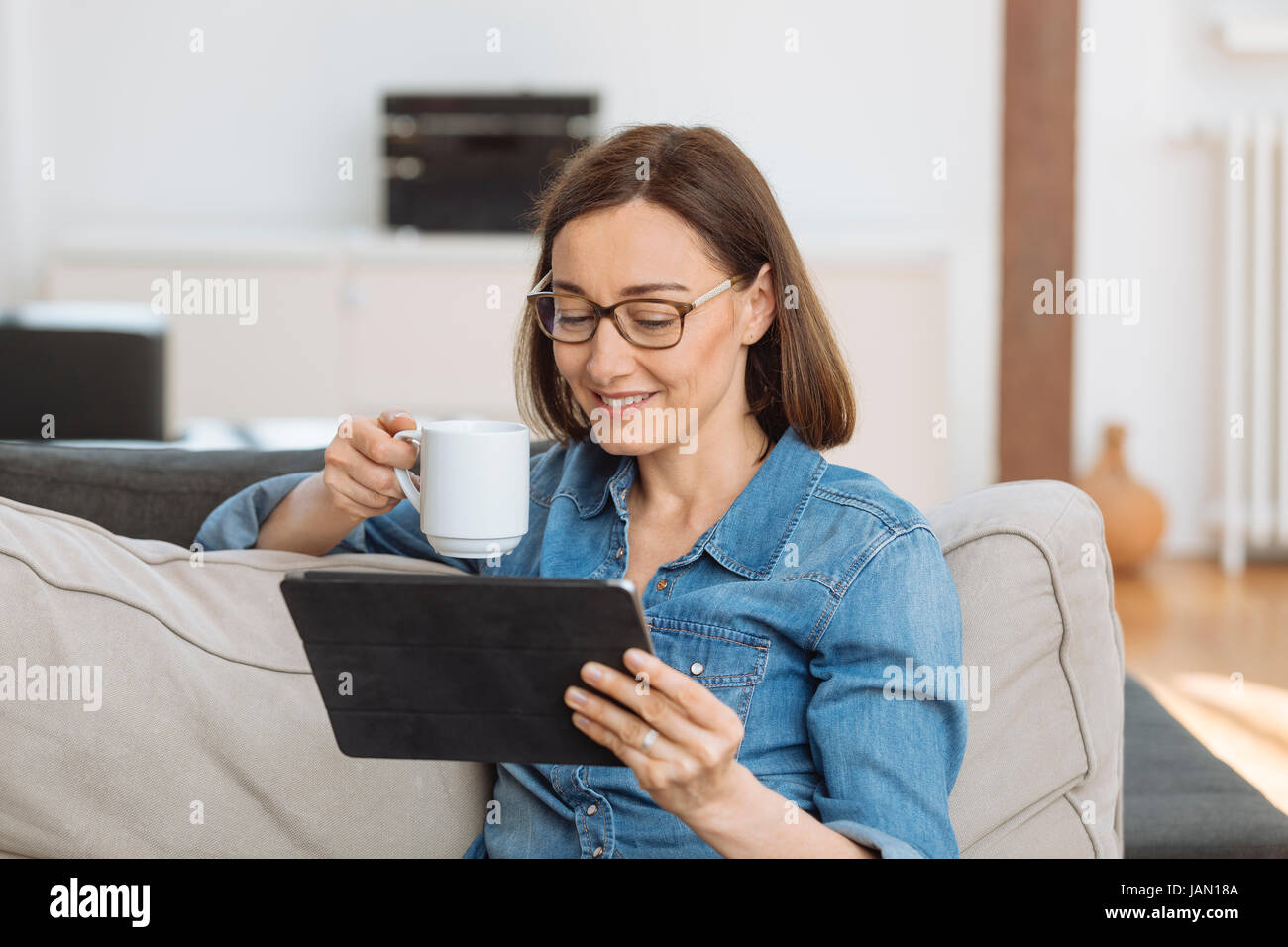 Mature woman on sofa hi-res stock photography and images - Alamy