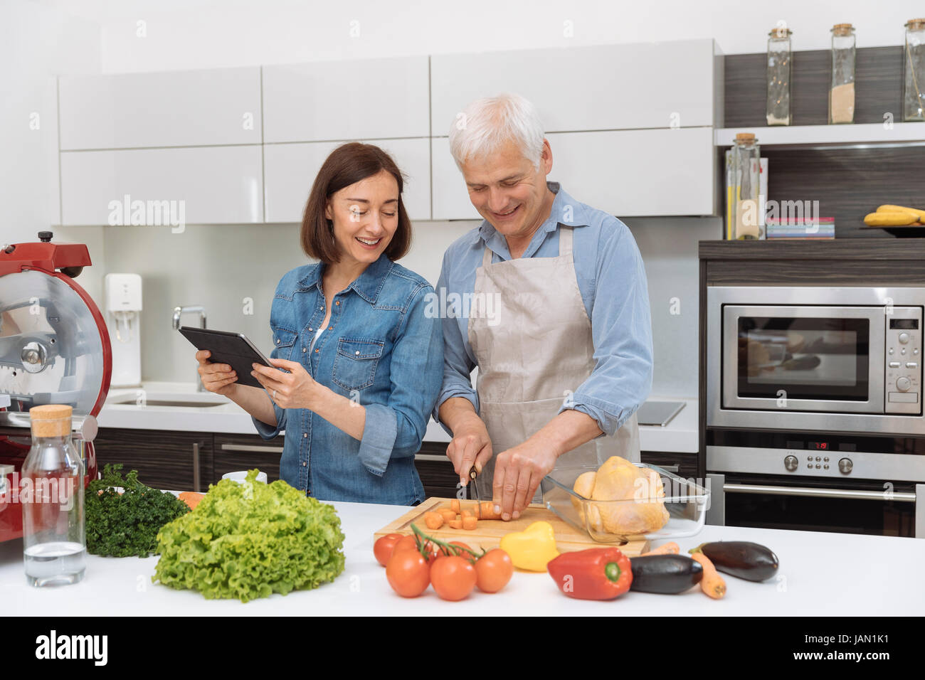 Mature couple cooking meal at home Stock Photo