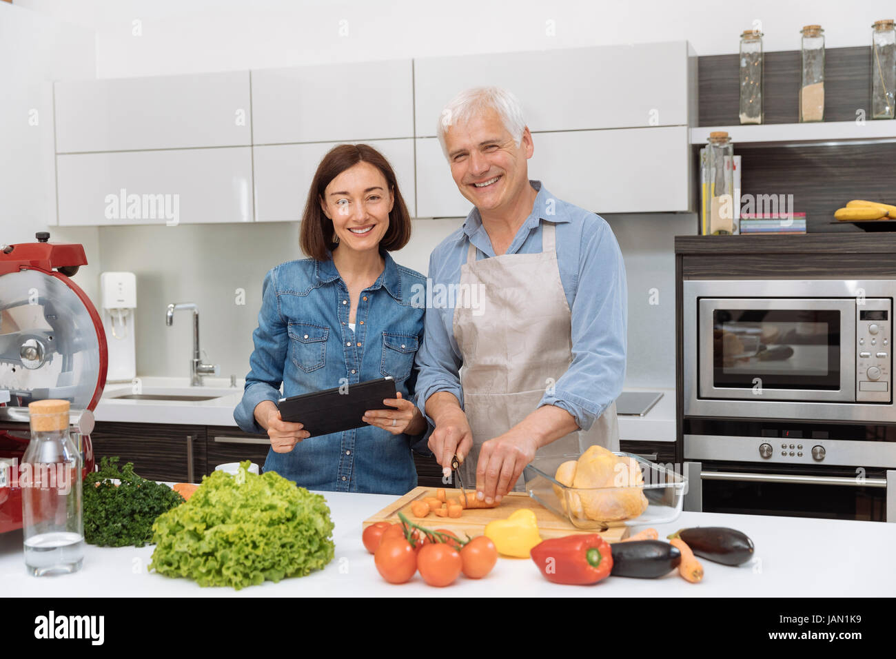 Mature couple cooking meal at home Stock Photo