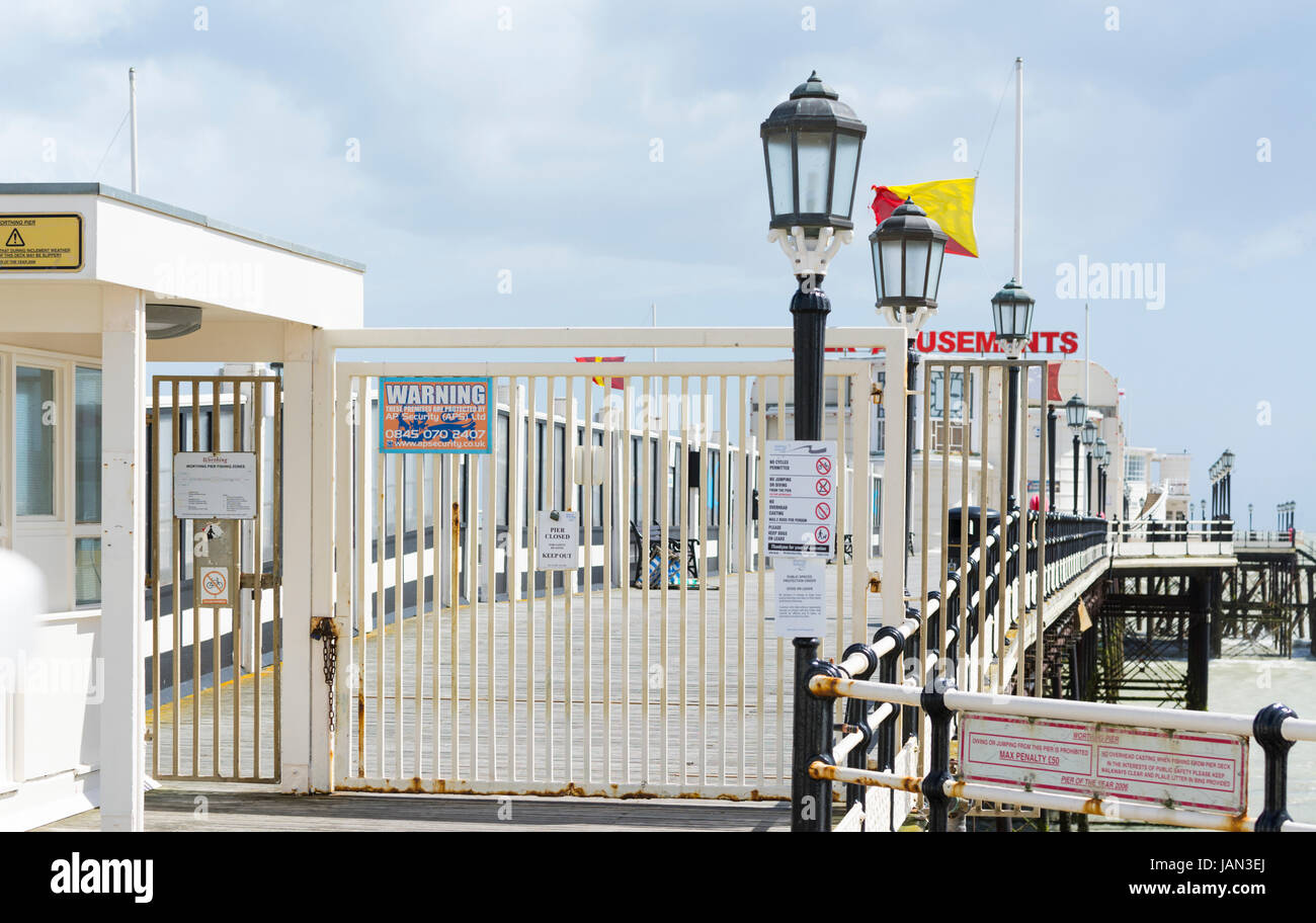 Worthing Pier with gates shut as it is closed during the day due to strong winds. Stock Photo