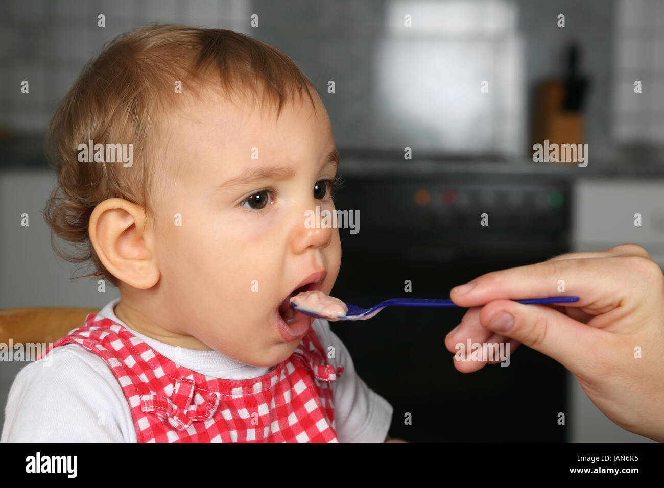 Mutter gibt kleinem Baby was zu essen, Baby öffnet den Mund Stock Photo