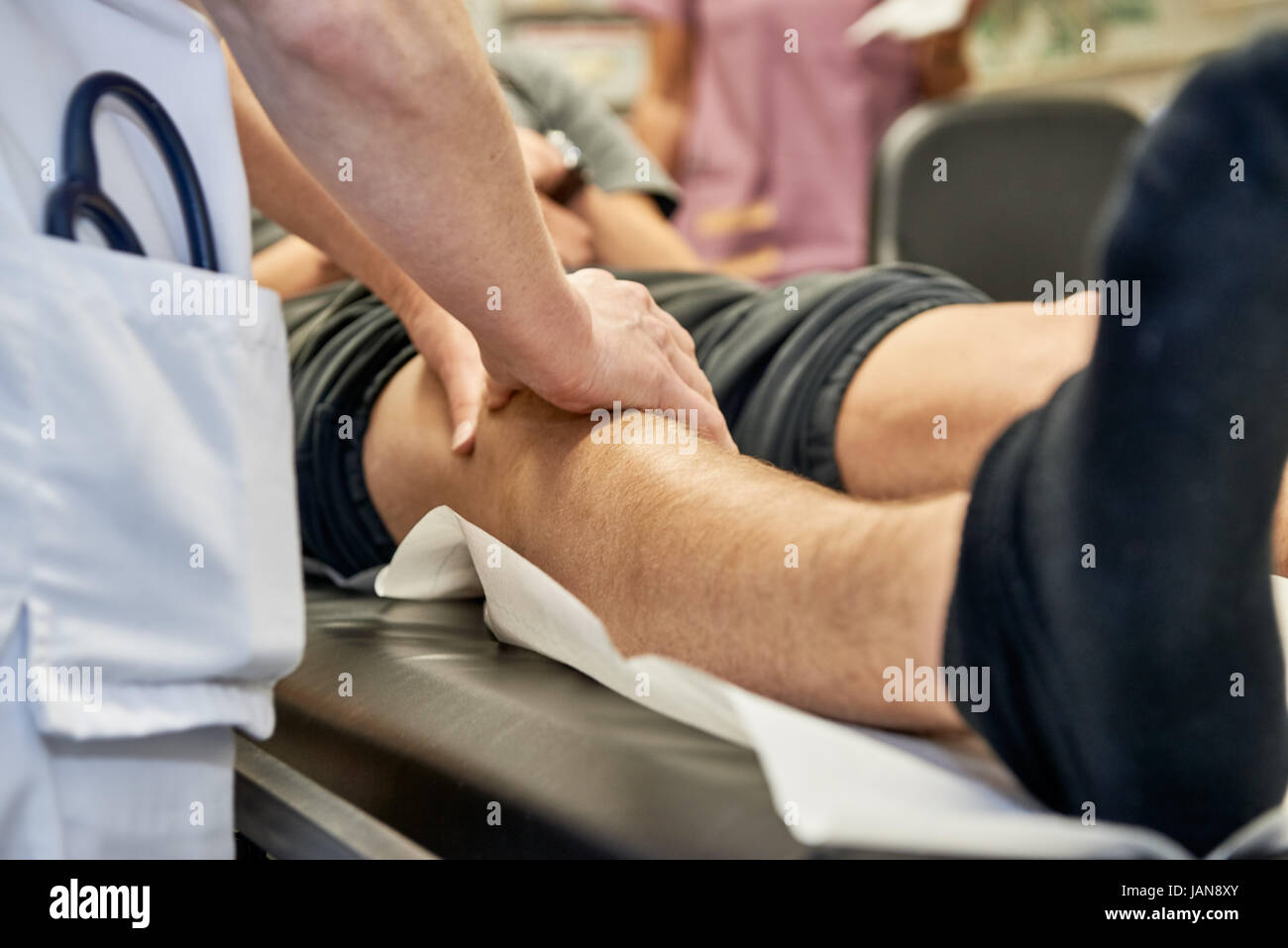 orthopedist is checking a knee by scanning with the hands Stock Photo