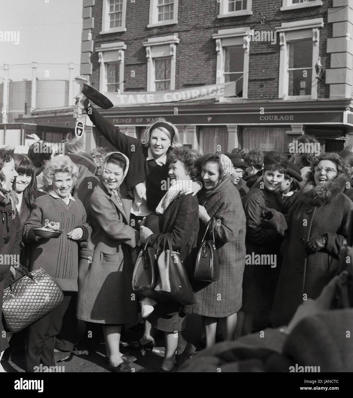 1965, historical, picture shows the winning lady holding aloft her frying pan outside the Prince of Wales pub in the annual pancake race on the Old Kent Road, London, SE1. Stock Photo
