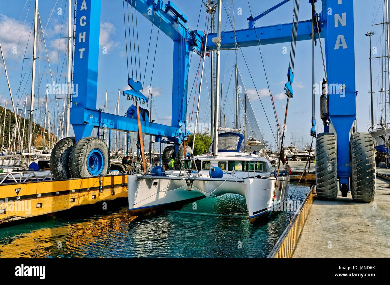 Cruising catamaran being lifted out of the water by marina boat crane.. Stock Photo