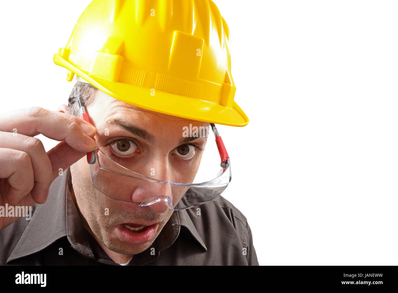 engineer with glasses and a helmet, watch in amazement straight in front of himself Stock Photo