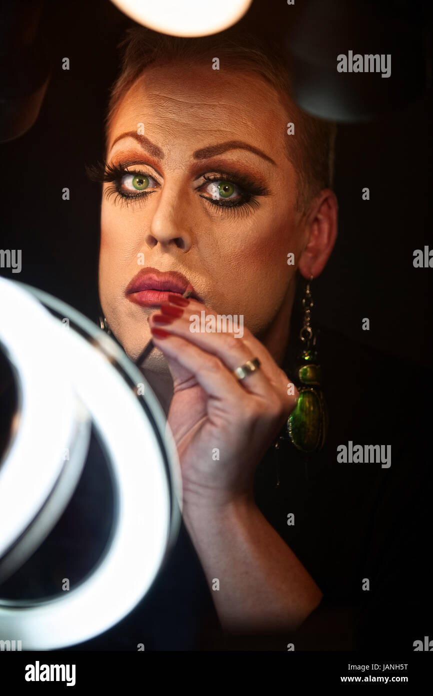 Serious Caucasian drag queen using lipstick Stock Photo