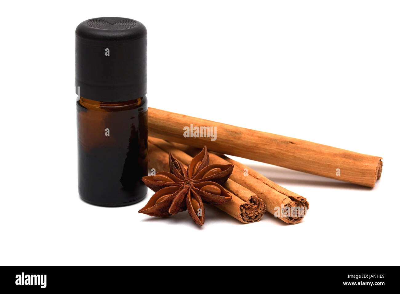 Essential oil with cinnamon sticks and anice on white background Stock Photo