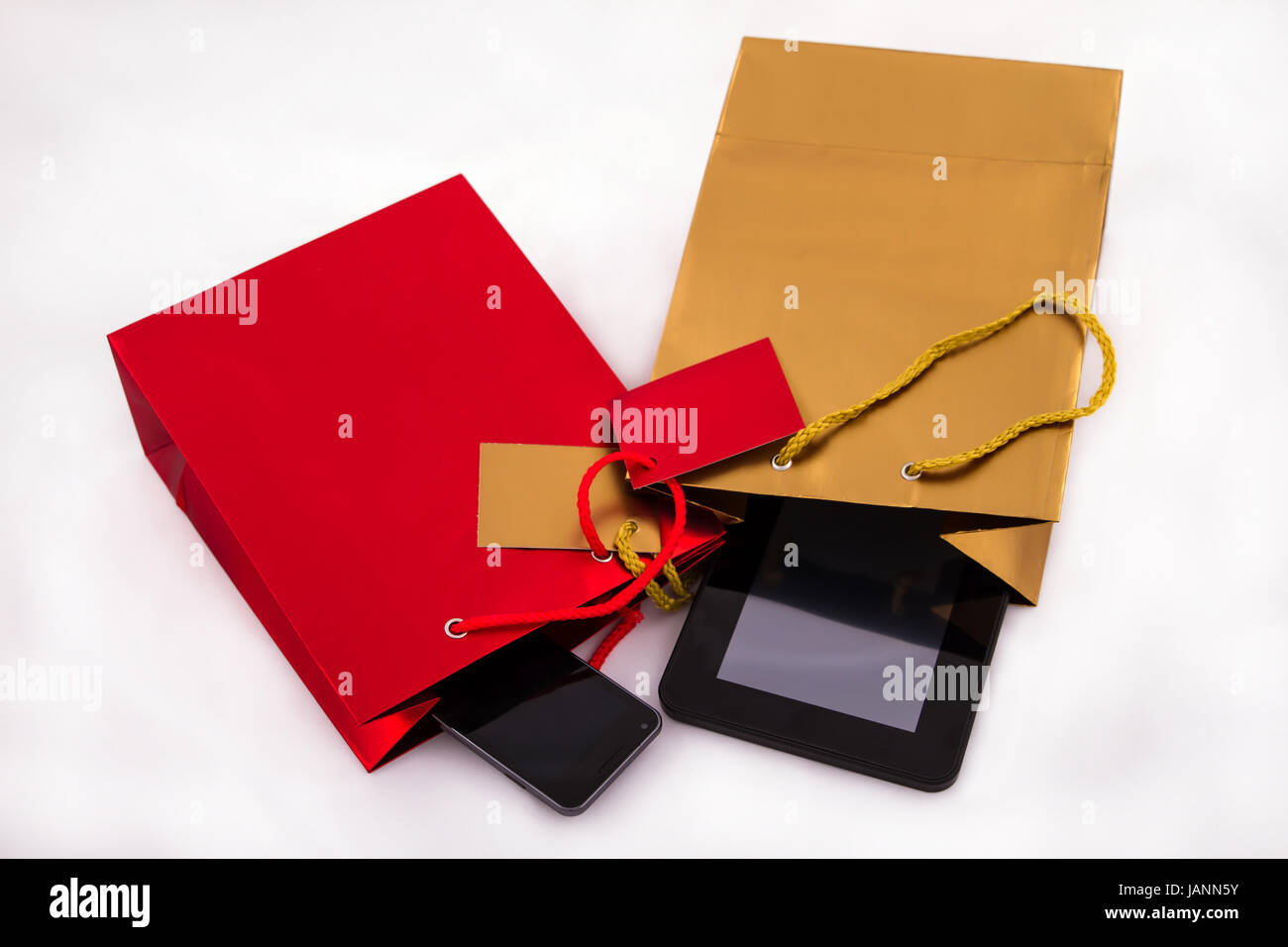 A red gift bag with a mobile and a gold gift bag with a tablet PC