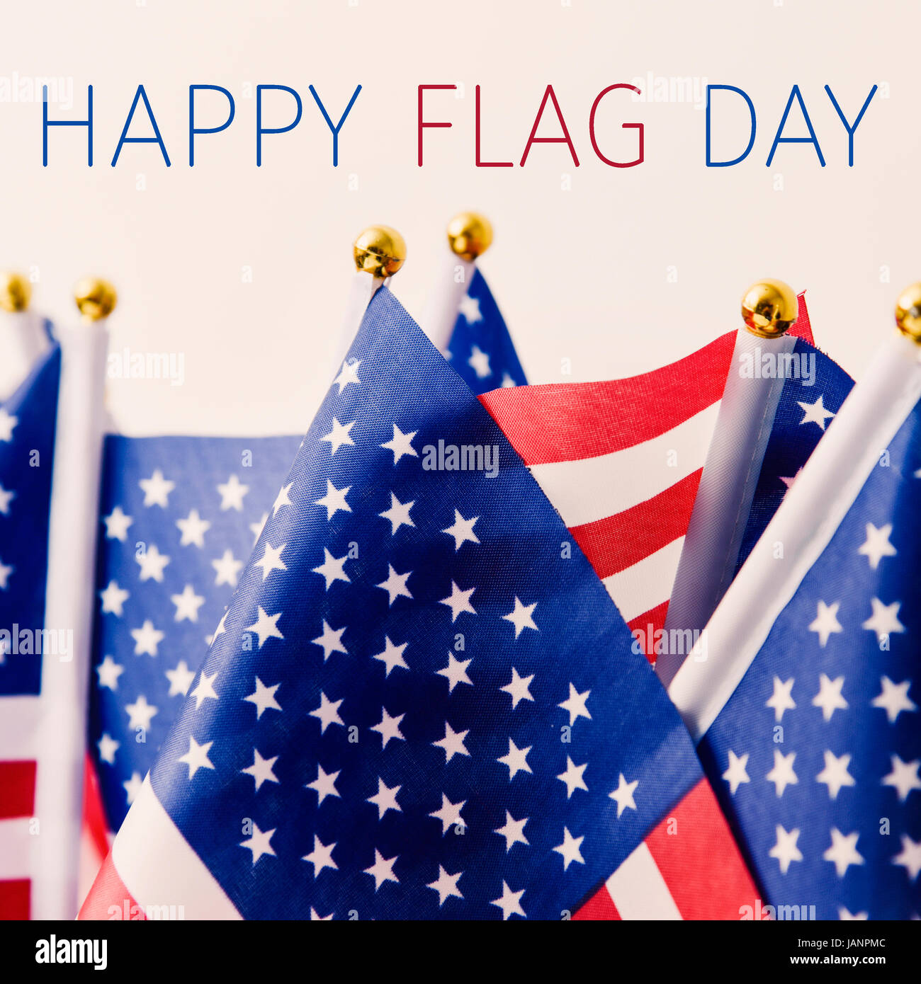 the text happy flag day and many flags of the United States against an off-white background Stock Photo