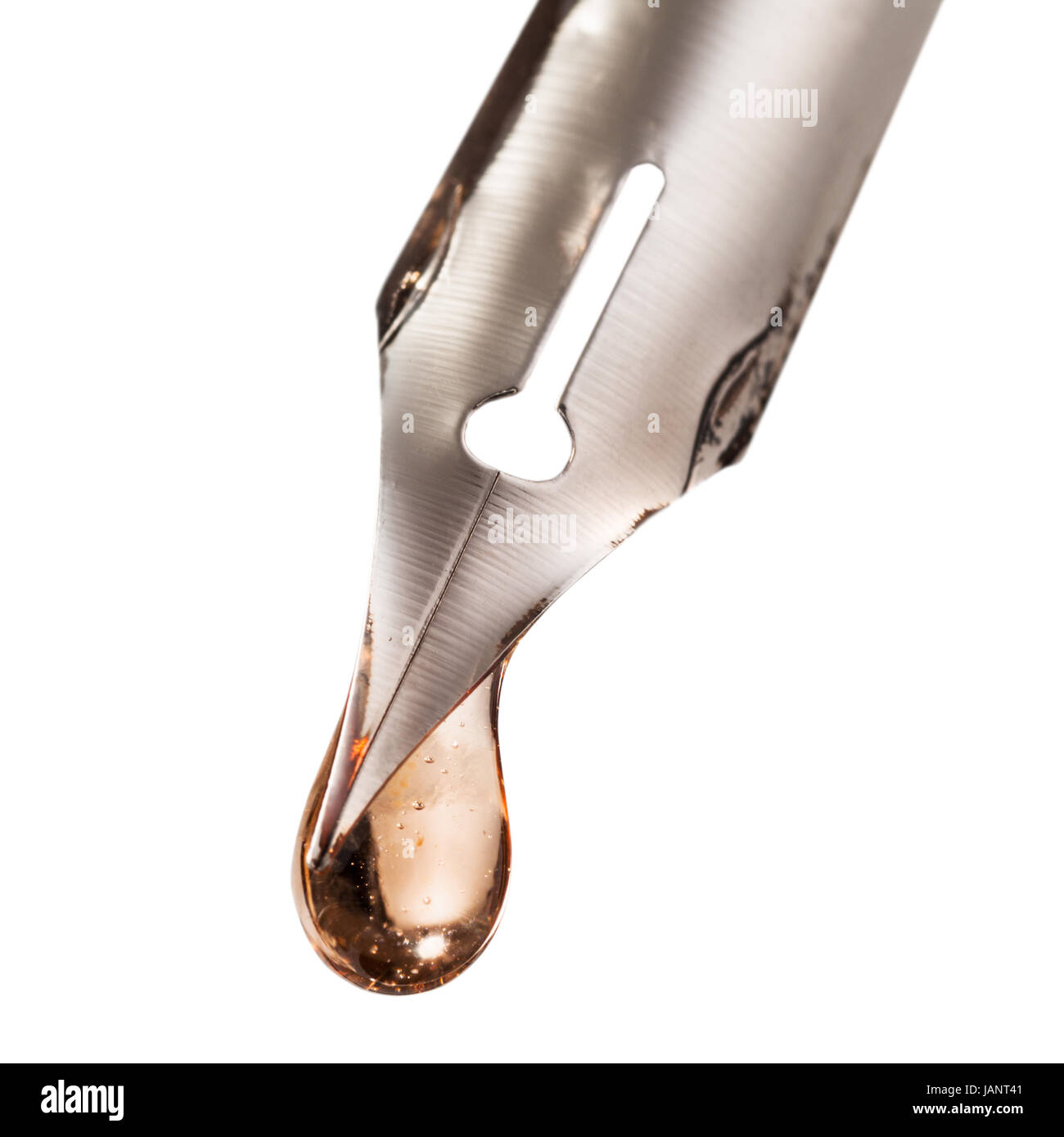 drop of transparent liquid on nib of pen close up isolated on white ...