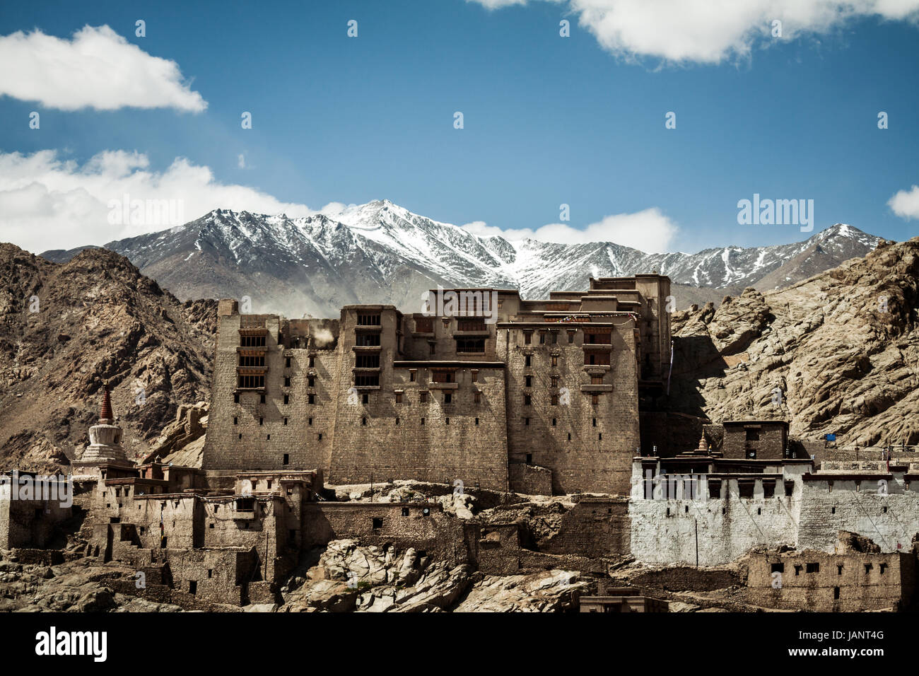 Dramatic location and Leh Palace with the white mountains of the Himalaya creating a beautiful snow capped peaks background a beautiful backdrop Stock Photo