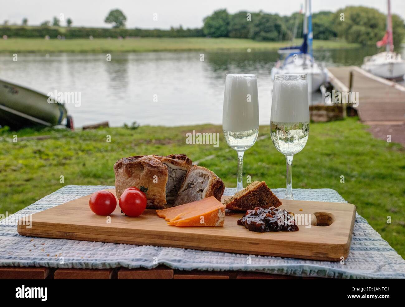Pork pie with cheese and wine on a picnic platter Stock Photo