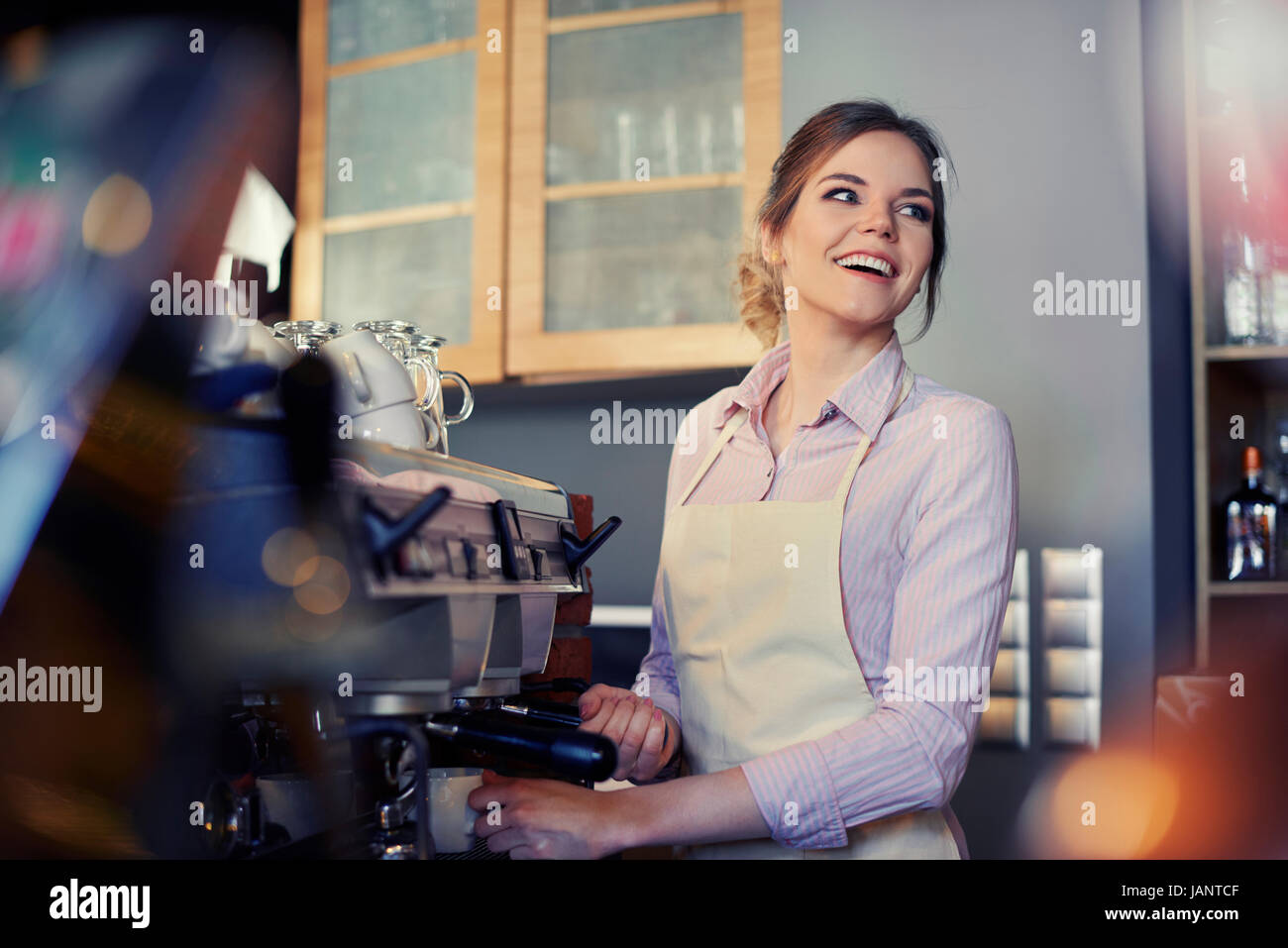 Female barista using coffee maker in cafe Stock Photo