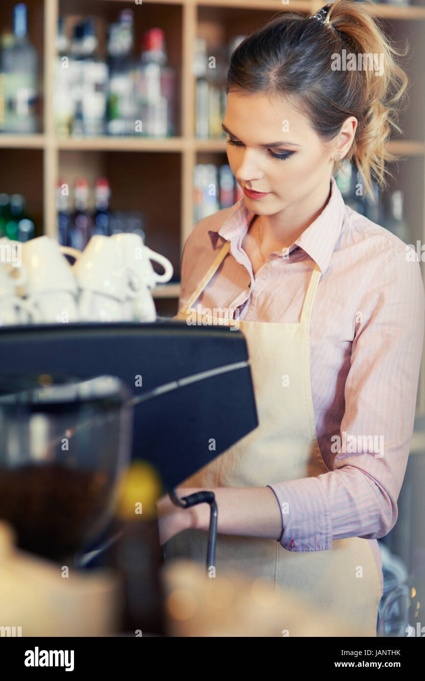 Waitress using coffee machine at work Stock Photo