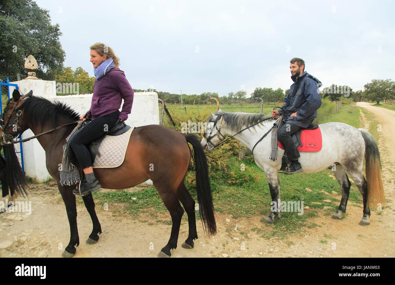 Young man and woman horse riding in countryside near Ronda, Malaga province, Sp Stock Photo