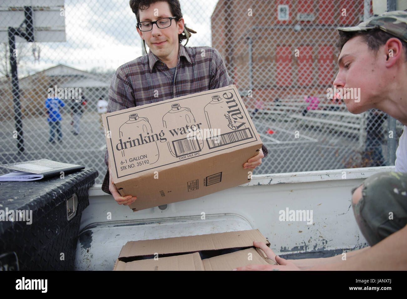 Volunteer Casey Pegg from Pittsburgh (left), and Ben Fiorillio also of Pittsburgh (right), load Fiorillo's pickup truck for home water deliveries in Charleston, WV. The two are part of the WV Clean Water Hub, an organization formed to deliver donated water and supplies to people needing safe drinking water after the Elk River chemical spill Jan. 9. Stock Photo
