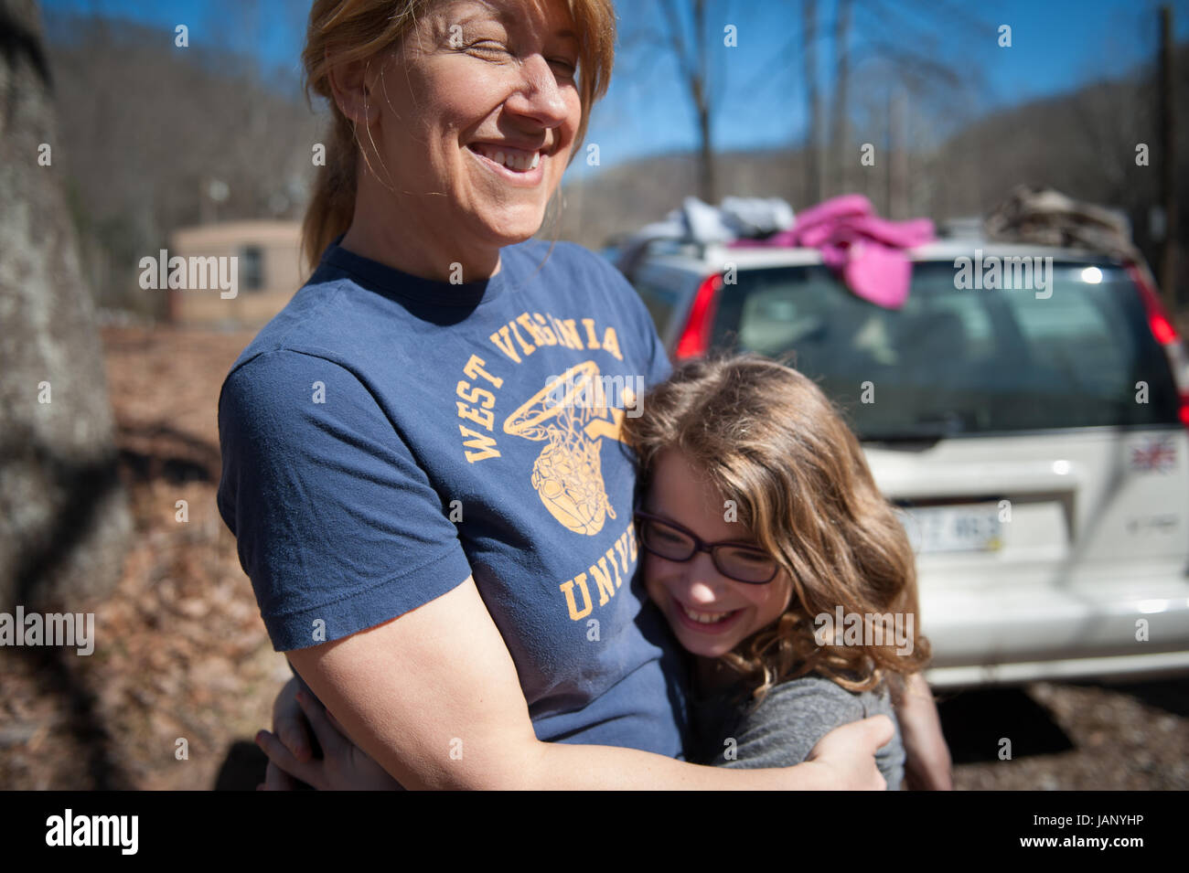 Volunteer Karan Ireland of Charleston, WV hugs her daughter Genevieve Ireland while helping with emergency water distribution at Three Fork hollow near Seth, WV.  Karen brought her children out because she believes strongly that it is very important for her children to lend a hand in the effort to help those who need water and to realize the scope of the crisis.   She is also one of the organizers of a new group in Charleston called Citizens Actively Protecting the Environment (CAPE) which sprung up as a result of the Elk River chemical spill.   CAPE is a loosely knit group of local environmen Stock Photo