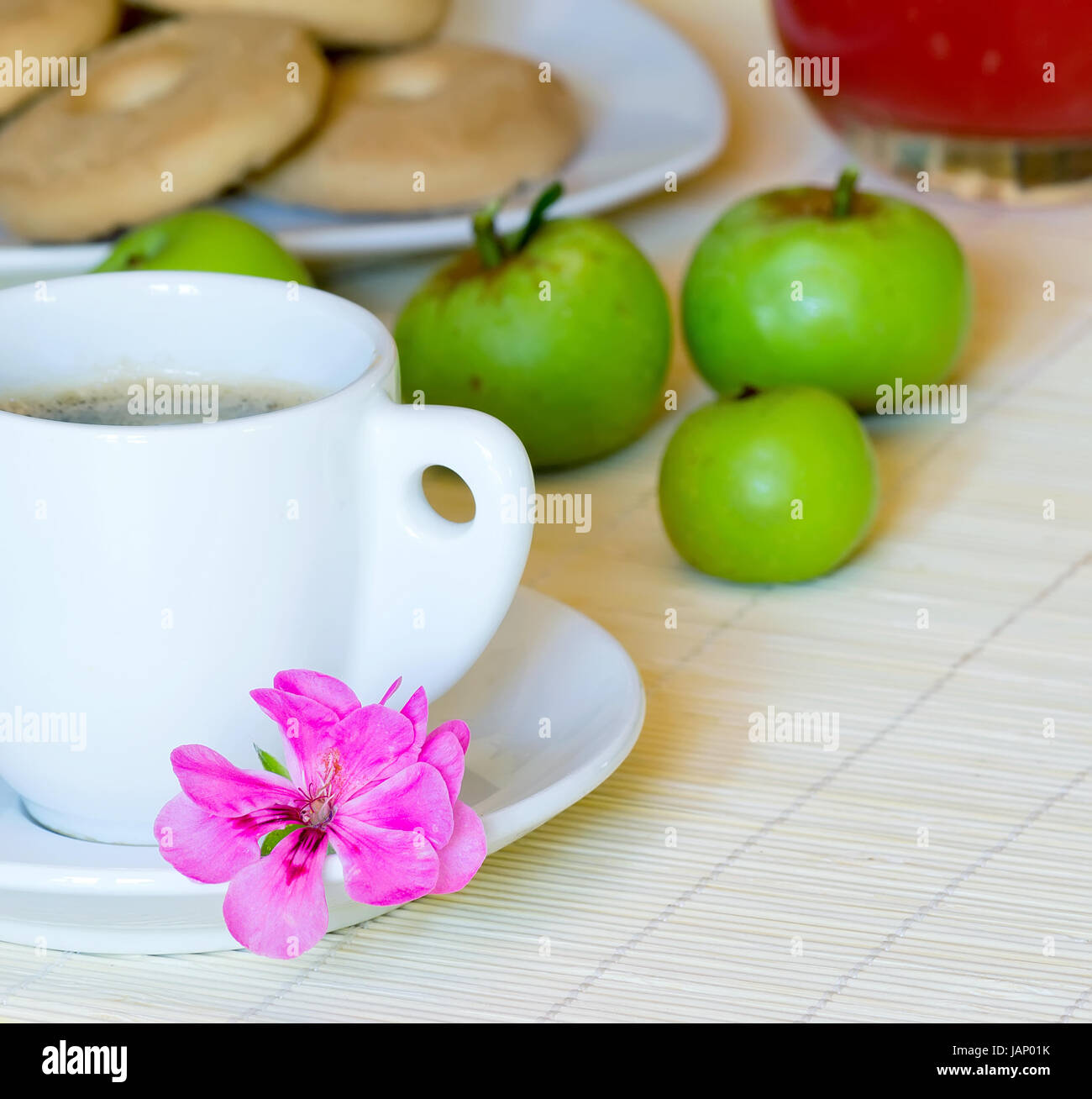 breakfast set with coffee, apples, cookies, fruit juice and a decorative flower Stock Photo