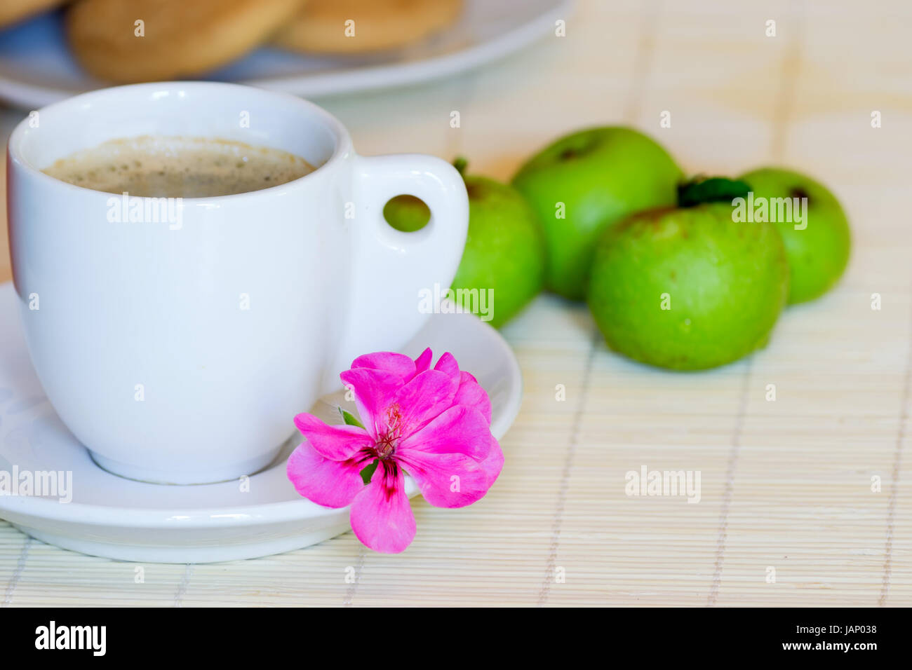 breakfast set with coffee, apple, cookies and a decorative flower Stock Photo
