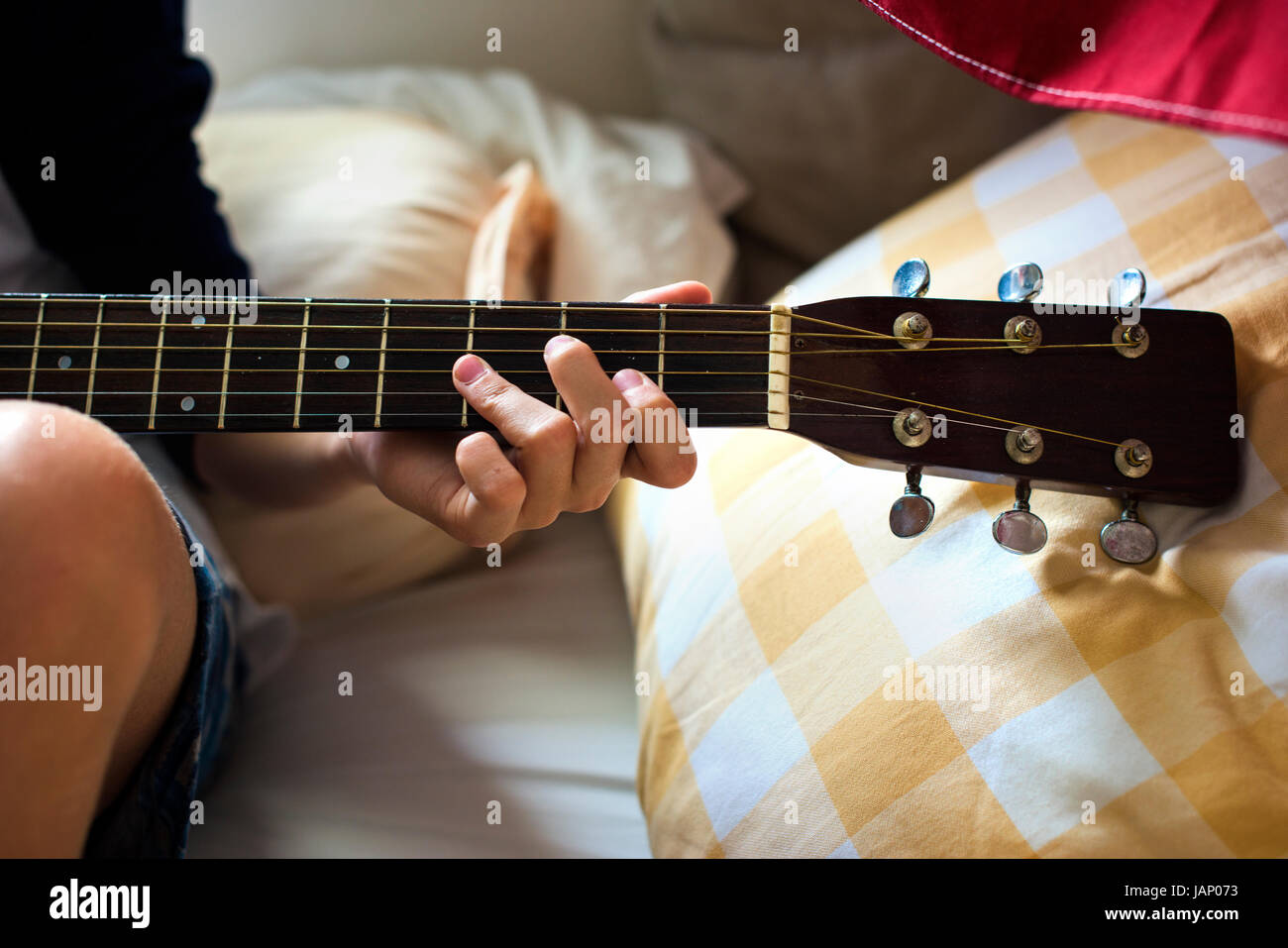 Closeup of young caucasian boy playing guitar on bed Stock Photo Alamy