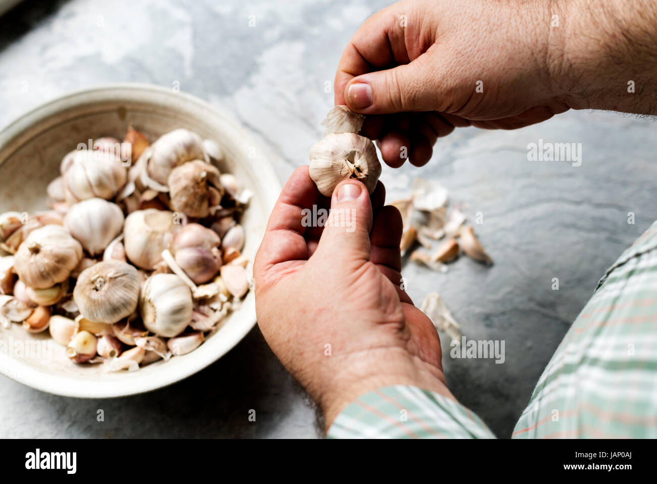 Closeup of hand peeling garlic Stock Photo - Alamy