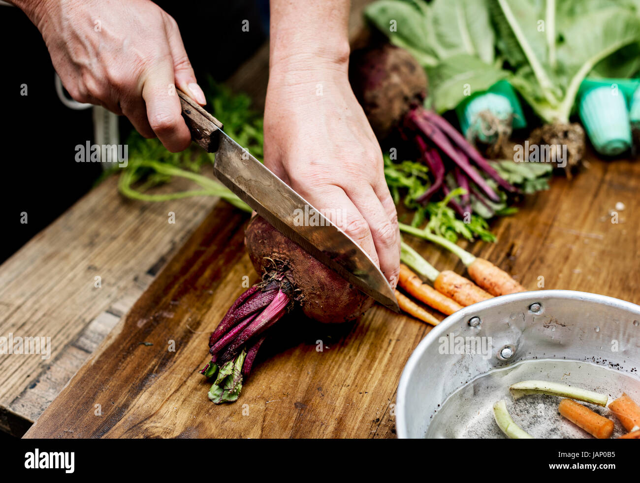 Closeup of hand with knife cutting fresh vegetable Stock Photo - Alamy